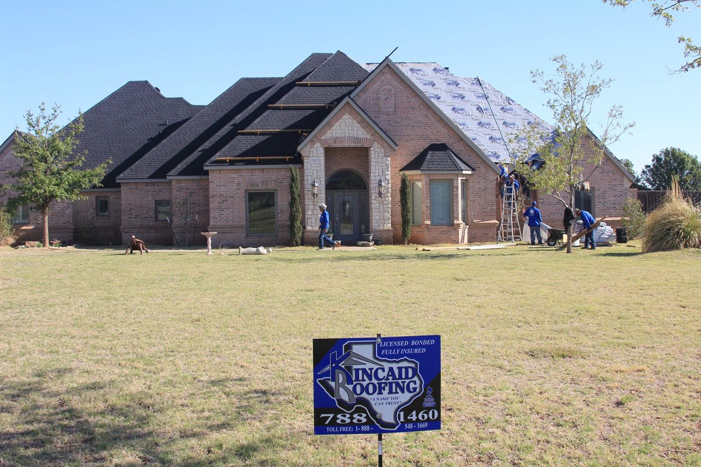 Kincaid crew mid-job on a big brick home, yard sign with 788-1460 on the lawn