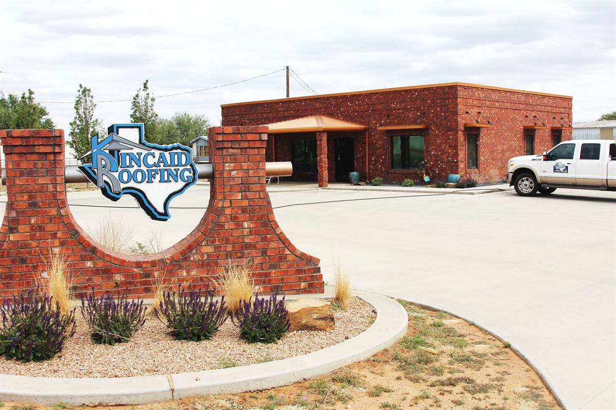 The brick Kincaid Roofing sign outside the office on 122nd Street